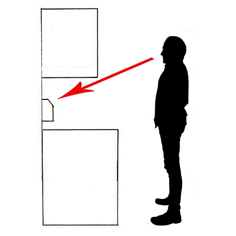 Une silhouette d'un homme regardant un objet. Une flèche rouge pointe vers un objet rectangulaire.