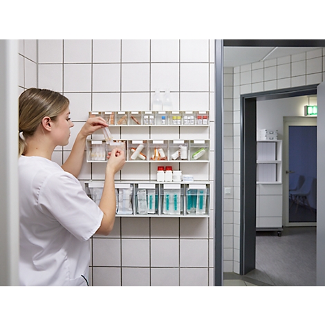 Infirmière prenant des médicaments dans une étagère de conteneurs à médicaments dans un hôpital.