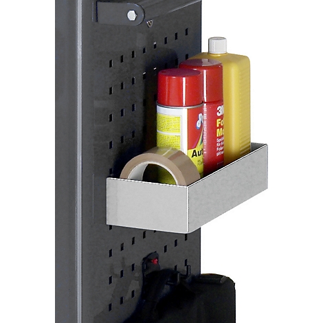 Detailaufnahme einer Werkzeugwand mit einer Metallablage, auf der verschiedene Werkzeuge und Flüssigkeiten stehen. Links daneben ist ein dunkler Behälter.