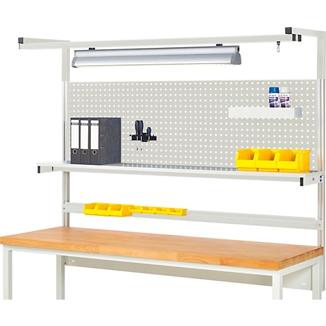 Werkbank mit Lochwand, Regalen und Arbeitsmaterialien. Oben Leuchte, rechts Schraubendreher und Behälter.