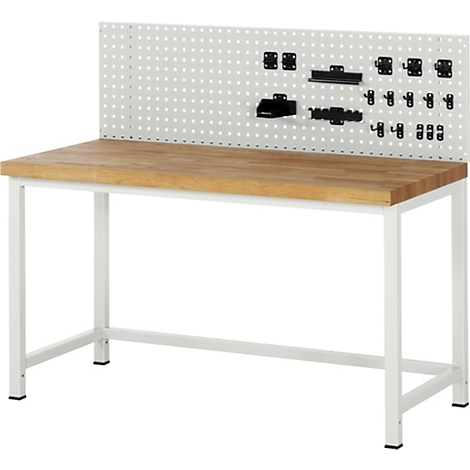 Établi avec cadre blanc, plateau en bois et panneau perforé avec outils. Des supports noirs sont fixés au mur.