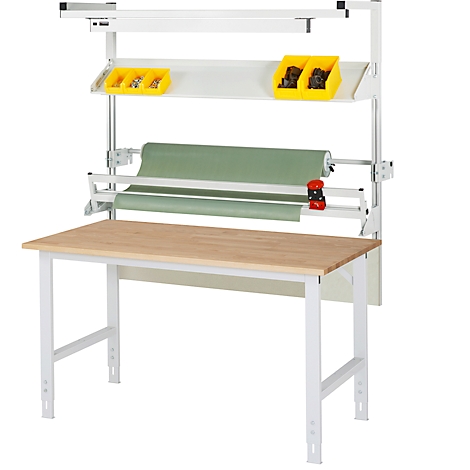 Werkbank mit Regal und Papierrolle; gelbe Behälter, hölzerne Tischplatte. Metallgestell und Beleuchtung.