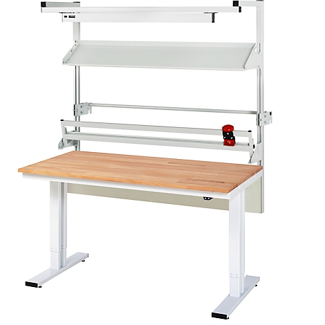 Steh-Sitz-Tisch mit Holzplatte. Darüber Regale, Beleuchtung und eine Papierrollenhalterung. Alles in Weiß und Silber.