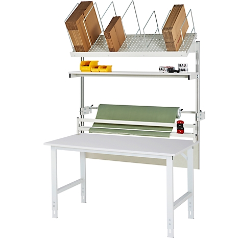 Arbeitstisch mit Regal, Packpapier und Kartons. Weißer Tisch, darüber Regale für Kartons und Kleinteile. Rollenpackpapier.