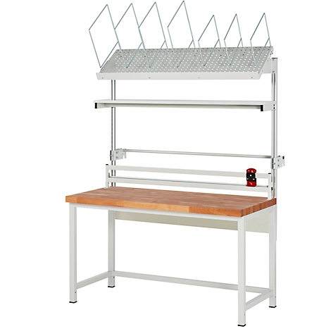 Werkbank mit Holzplatte, weißem Metallgestell und Regalen. Oben befindet sich ein Gitter für Papiere. Links ist ein Papierrollenhalter.