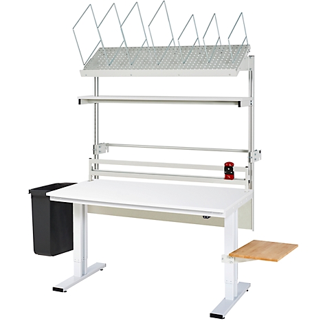 Weißer, höhenverstellbarer Arbeitstisch mit Ablagen, Papierhalter, Papierrolle, Papierkorb und zusätzlichem Brett.