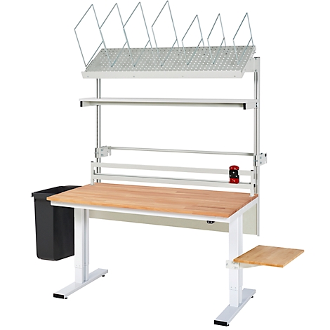 Ein weißer Arbeitstisch mit Ablagen, Papierrollen und Mülleimer. Die Tischplatte ist aus Holz.