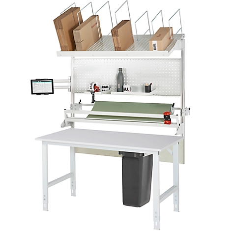 Weißer Packtisch mit verschiedenen Paketen, Rollenpapier, Abfalleimer und Tablet-Halterung.