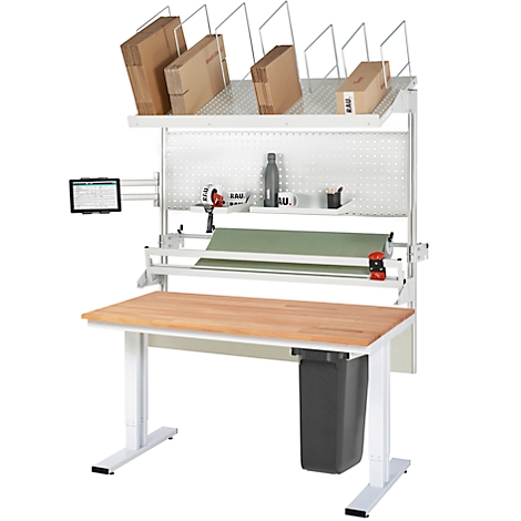 Arbeitstisch mit Packstation, brauner Tischplatte, Pappkartons und Zubehör. Rechts ein Mülleimer.