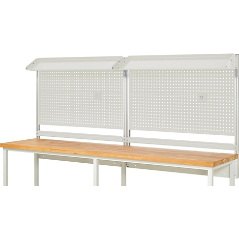Établi avec panneau perforé et éclairage. Dessus en bois, cadre blanc. Le panneau perforé est perforé de trous.