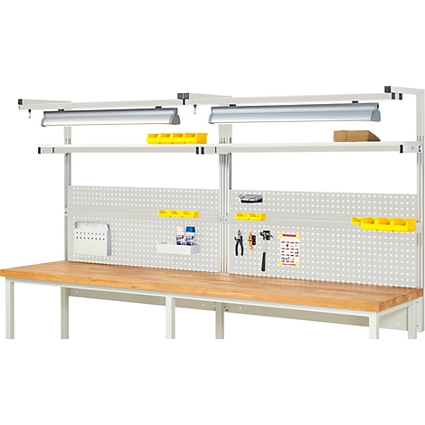 Établi avec panneau perforé, étagères et éclairage. Espace de travail pour l'artisanat ou l'atelier avec des outils. Plateau en bois.