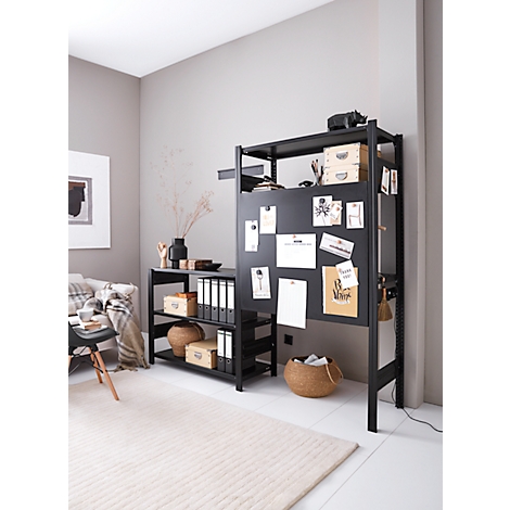 Système d'étagères ouvertes noires avec tableau d'affichage. Des boîtes, des dossiers et des décorations se trouvent sur les étagères. Des notes sont attachées au tableau d'affichage.