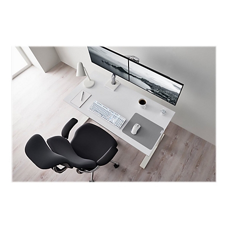 Schreibtisch mit zwei Monitoren, Tastatur, Maus, Stuhl, Lampe und Kaffeetasse. Einrichtung in hellen Farben.