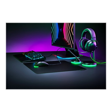 Gaming-Set mit Tastatur, Maus, Mikrofon und Headset auf einem Schreibtisch in buntem Neonlicht.