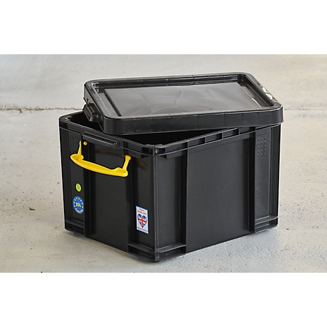 Black plastic box with yellow handle and lid. Two stickers are on the floor.