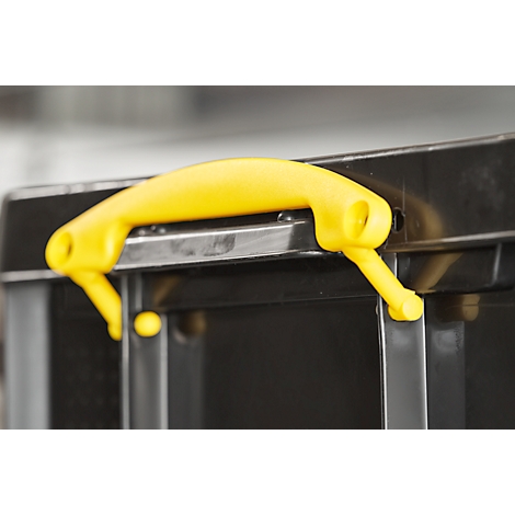 Yellow handle on a black box. Close-up.
