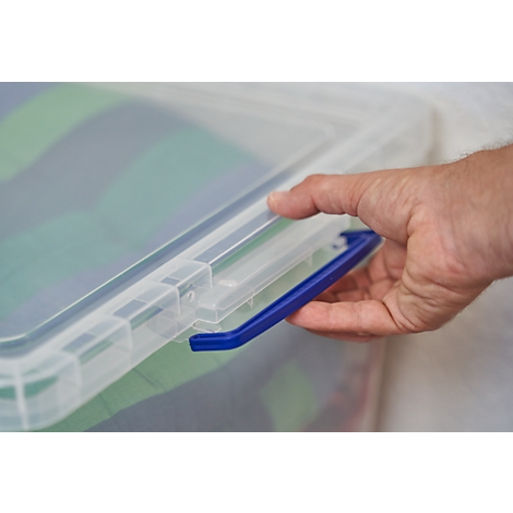 A hand opens a blue handle on a transparent plastic box containing fabrics.