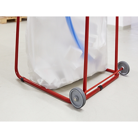 Red trash bag holder with wheels and a filled, white trash bag.
