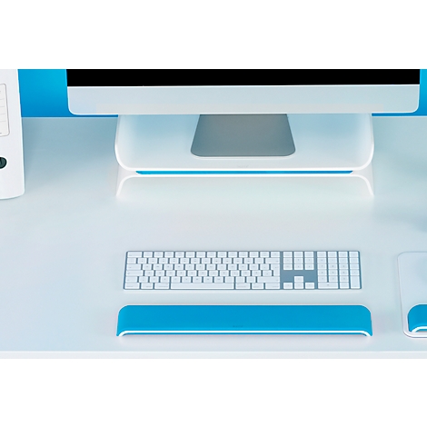 Gros plan d'un bureau avec des accessoires informatiques blancs et bleus. Comprend un clavier, un repose-poignet et un moniteur.