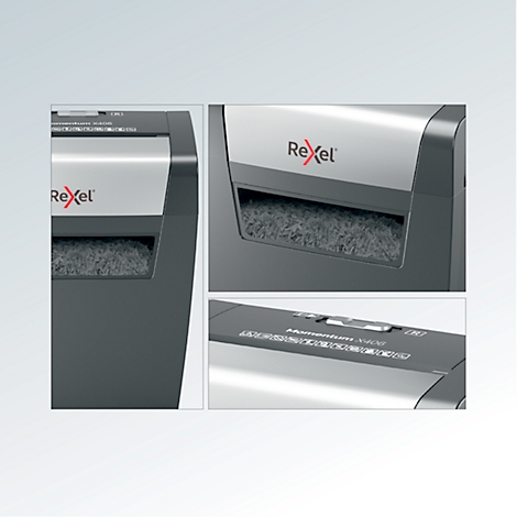 Close-up of a black paper shredder. The Rexel logo is visible. Shredded paper pieces are in the collection container.