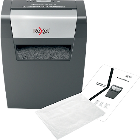 Shredder with shredded paper, next to an instruction manual and a bag.