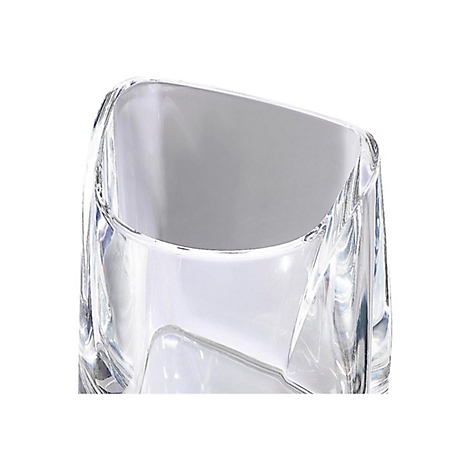 Gros plan d'un verre transparent et carré. Les bords obliques et la forme créent des reflets de lumière. Le fond est blanc.