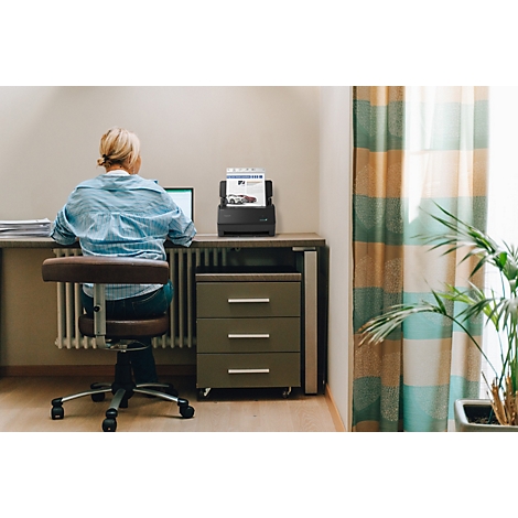 Eine Frau arbeitet im Homeoffice an einem Schreibtisch mit einem Dokumentenscanner.