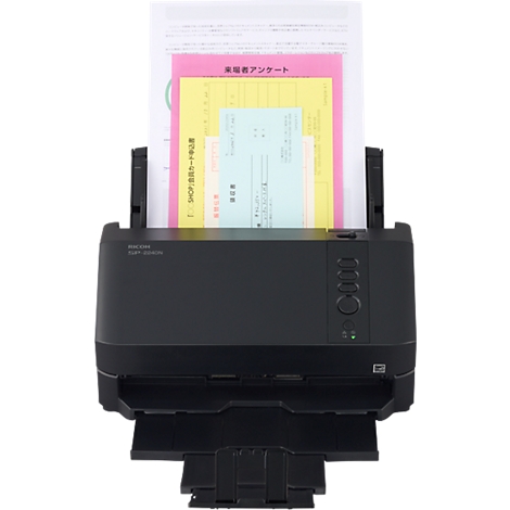Schwarzer Ricoh Dokumentenscanner mit eingelegten, verschiedenfarbigen Papierblättern vor neutralem Hintergrund.