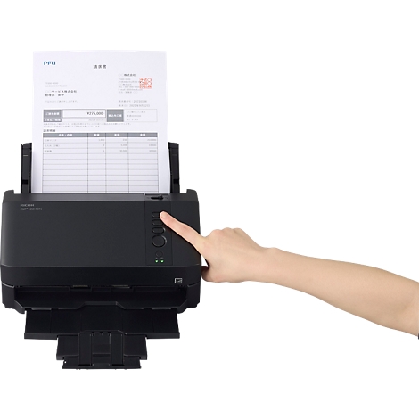 Hand drückt einen Knopf an einem schwarzen Dokumentenscanner, in dem ein Blatt Papier liegt.