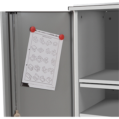 Grey cabinet door with a drawing attached with red magnets. Inside, a cabinet compartment with shelves can be seen.