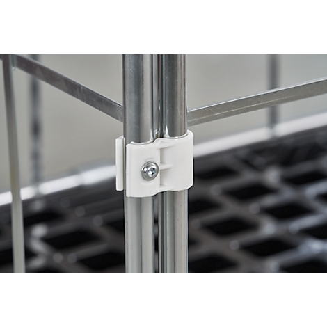 Close-up van twee zilveren metalen buizen verbonden door een witte kunststof connector. Op de connector is een schroef zichtbaar.