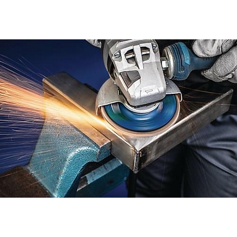 Le métal est travaillé avec une meuleuse d'angle, des étincelles volent.