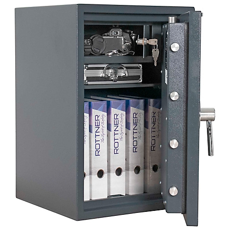 Coffre-fort en acier ouvert avec contenu : dossiers, appareil photo, porte-documents. Coffre-fort gris, serrure et clés visibles.