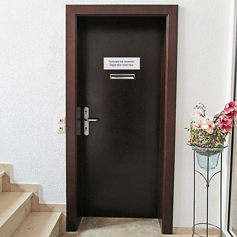 Porte brun foncé avec panneau "Formular für erwarten, Registration insert here". Fleurs sur pied à droite, escalier à gauche.