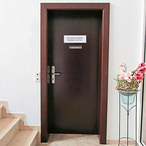 Une porte sombre avec un panneau indiquant 'Formulaires ici'. Un vase à fleurs se trouve à droite.