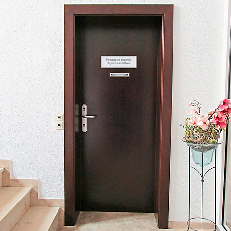Porte en bois sombre avec panneau : "Formularsche unterlagen, Registration insert here". Fleurs à droite.