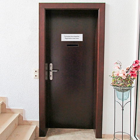 Porte marron avec panneau: "Demande de bordereaux de rendez-vous. Inscription ici." Escalier à gauche, fleurs à droite.