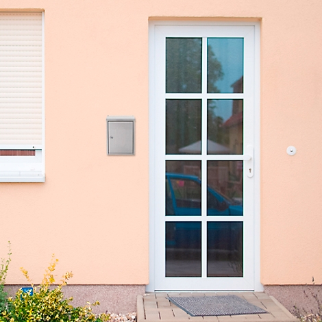 Helle Hausfassade mit weißer Tür, Fenster, Rollladen und Briefkasten. Im Fenster ein blaues Auto.