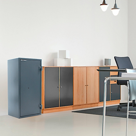 Grijze kluis naast een kast in een kantoor, met bureau en stoel erachter.