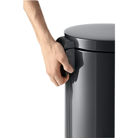 Person opening a dark trash can by operating the handle with the hand.