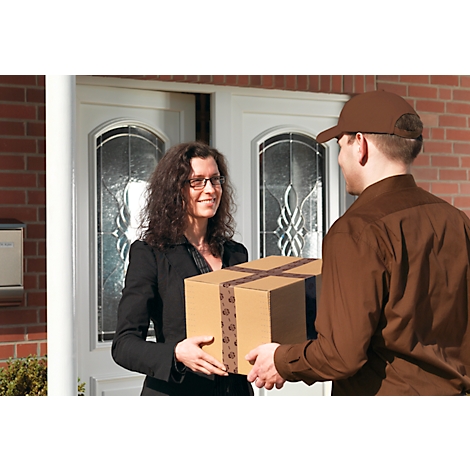 Un livreur remet un colis à un client à la porte d'entrée. La femme sourit.