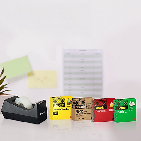 Gros plan sur des fournitures de bureau, dont un distributeur de ruban adhésif noir et quatre paquets de ruban adhésif Scotch de couleurs différentes.