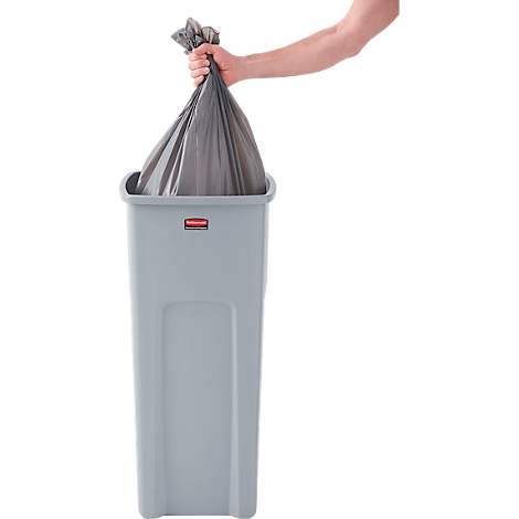 Person hebt gefüllten schwarzen Müllsack aus grauem Mülleimer. Der Mülleimer hat ein rotes Logo. Heller Hintergrund.