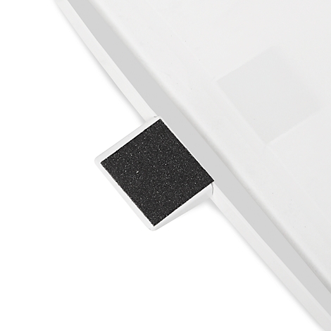 Detailaufnahme von einem weißen Objekt mit einem schwarzen, rechteckigen, strukturierten Element.