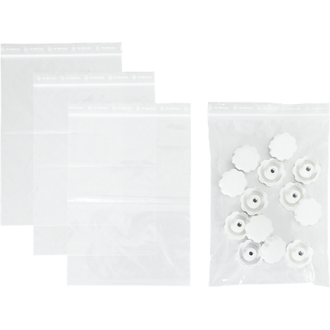 Drie lege plastic zakken naast een zak met witte knoppen.