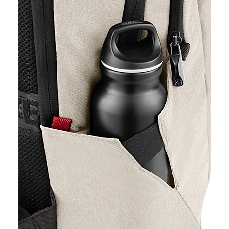 Bouteille d'eau noire dans la poche latérale d'un sac à dos beige.