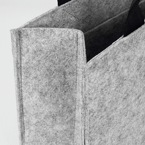 Gros plan d'un sac en feutre gris avec une poignée noire, montrant la texture et les coutures.