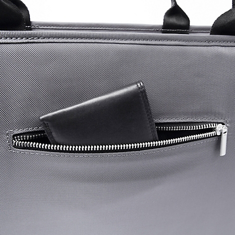 Portefeuille noir dans une poche zippée d'un sac à main gris.