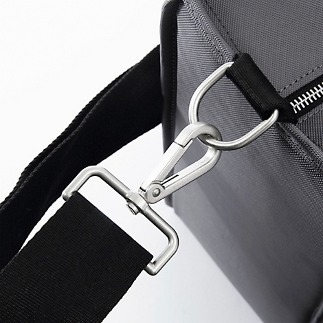 Gros plan d'un sac à dos en tissu gris-noir avec un mousqueton argenté et une bandoulière noire.
