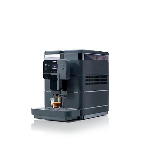 Dunkelgraue Kaffeemaschine, in der gerade Kaffee in eine Tasse läuft, auf weißem Hintergrund.